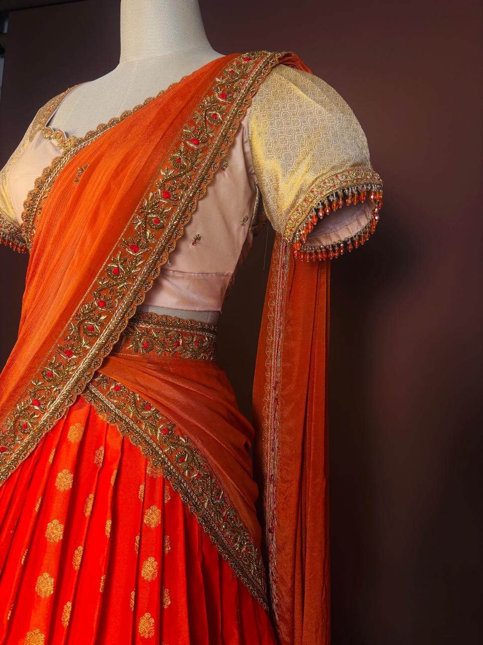 Vibrant Tangerine and Gold Silk Half-Saree (Langa Voni) with Intricate Zari Brocade and Beaded Zardozi Blouse